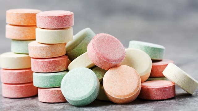 Stacked multicolor Tums antacid tablets on a counter, illustrating calcium carbonate overdose risks, heartburn relief misuse, and dangers of exceeding daily dosage limits