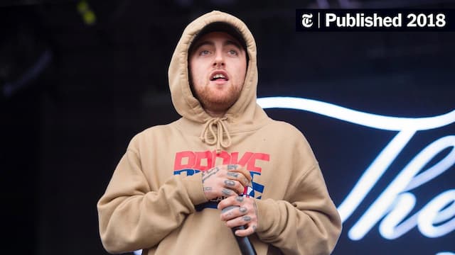 Mac Miller performing on stage in 2018, wearing a tan hoodie and holding a microphone, highlighting the late rapper’s iconic look before his tragic fentanyl-related overdose.